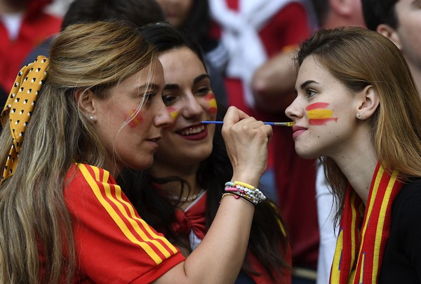 A fan has a flag painted in the colours of the Spanish flag, on her face prior to the start of the Euro 2020 soccer championship semifinal match between Italy and Spain at Wembley Stadium in London, Tuesday, July 6, 2021. (Andy Rain/Pool via AP)